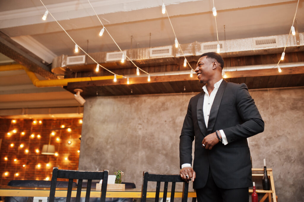 strong powerful african american man in black suit posed in cafe